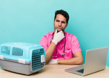 hispanic handsome man thinking, feeling doubtful and confused. veterinarian concept