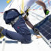 A worker measures solar panels with a meter to install them on the rooftop